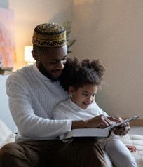 a parent reading to his daughter