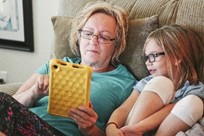 a mum and daughter looking at a iPad