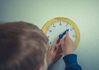 a child changing the time on a clock